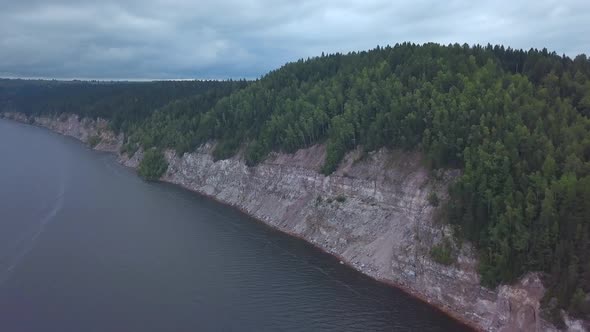 Aerial View of the Steep Cliff Above the Calm River Surface