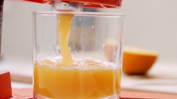 Super slow motion of fresh orange juice squeezed using a manual squeezer