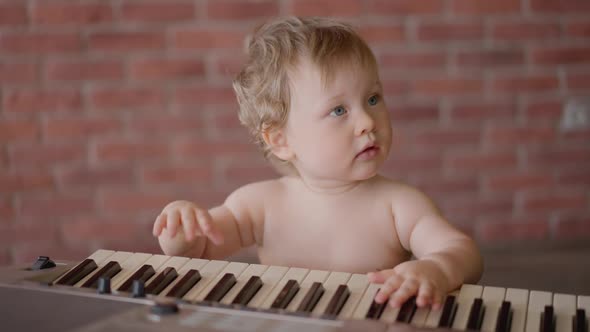 Asian Baby Girl Toddler Playing Electric Piano Sit Down on the Floor Tapping on Keyboard Music