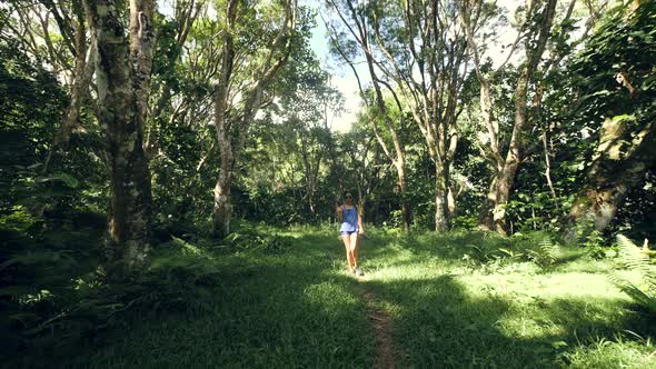 Carefree Young Woman Walking on the Green Path in the Middle of the Forest