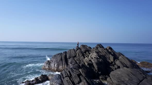 Lady Silhouette Meditates in Yoga Pose on Cliff Top at Waves