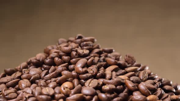 Arabica coffee beans rotating on jute canvas background