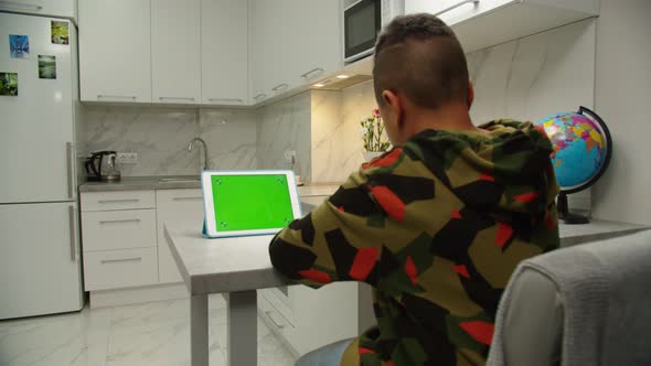 Kid Scrolling Chroma Key Green Screen on Digital Tablet Indoors