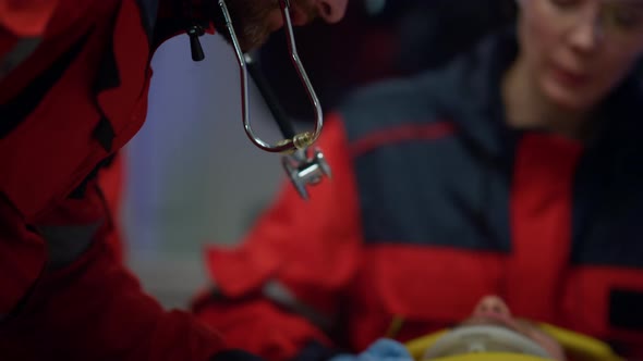 Paramedic Listening to Patient Heartbeat