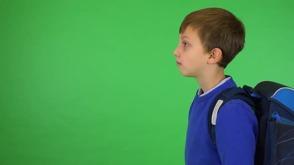 A Young Cute Boy with a Schoolbag Turns To the Camera and Smiles - Green Screen Studio