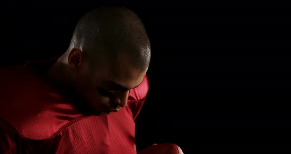 American football player holding a football with both his hands 