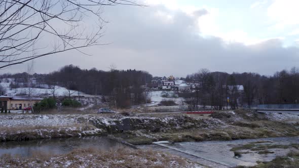 Limanowa, South Poland: Pan shot of a car driving in a mountain by the river in a country side