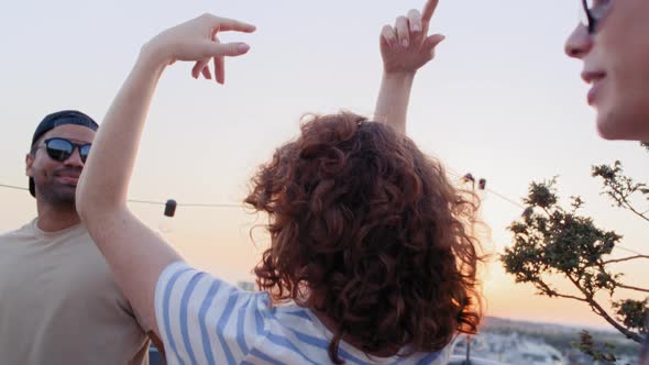 Group of multi ethnicity friends dancing at the party in top of the roof. Shot with RED helium camer