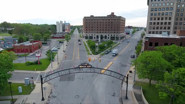 A descending drone shot focuses on the lighted Vehicle City Sign and archway above Saginaw Street in