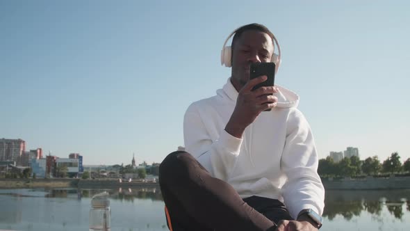 Black Man Scrolling On His Phone Outdoors