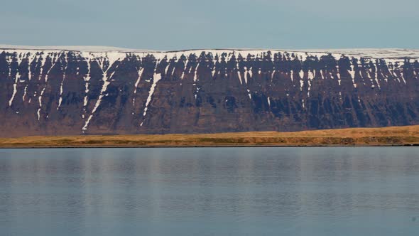 Snow Covered Mountains Under Blue Sky Over Fjord