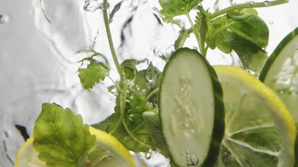 Mint and Slices of Juicy Cucumber and Lemon Fall Into Water