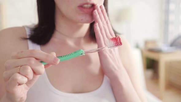 Close Up Young Woman Notices Blood on the Brush and Mouth Pain