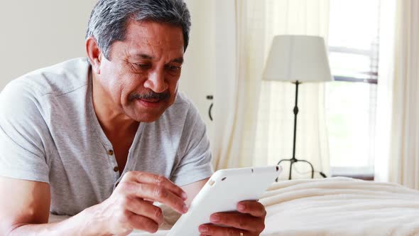 Senior man using digital tablet in bedroom 4k