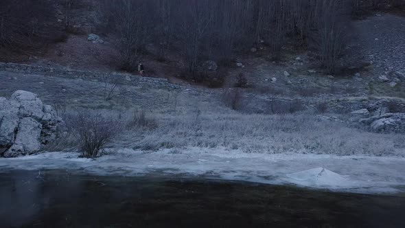 Young man walking in the forest. Top view of  frozen Lake  in Montenegro.