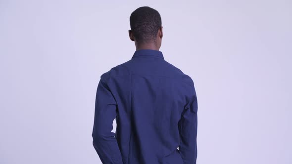 Rear View of Young African Businessman Waiting and Thinking