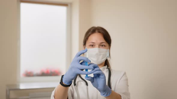 Doctor's Hands Hold Syringe with Vaccine at Hospital