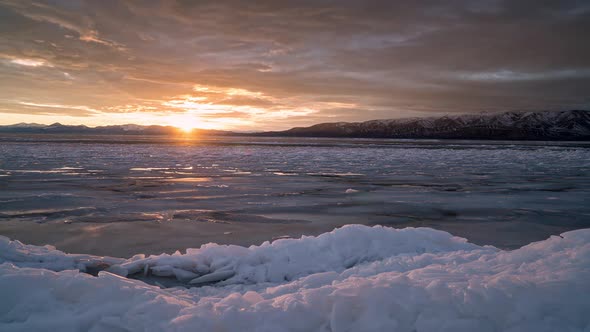 Winter sunset time lapse moving past ice on frozen Utah Lake