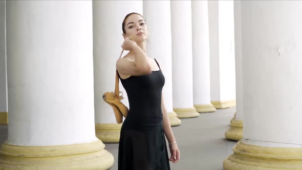 Camera Approaches To Slim Young Confident Woman Putting Yellow Pointes on Shoulder