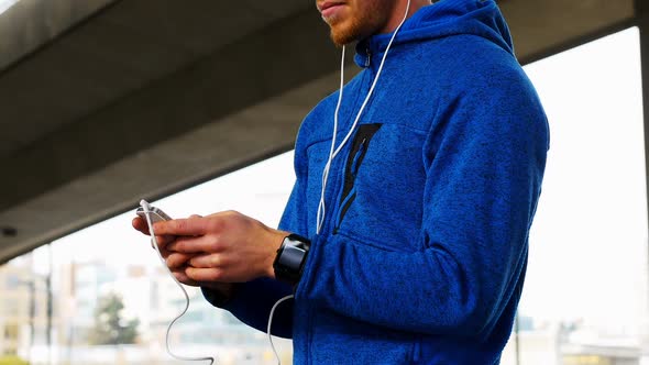 Young man with headphones listening to music on mobile phone