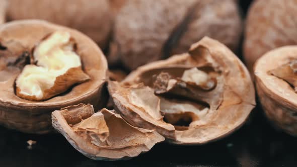 Lot of Walnuts in the Shell are Spinning on a Black Background