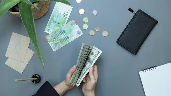 Woman fanning through large stack of US currency banknotes