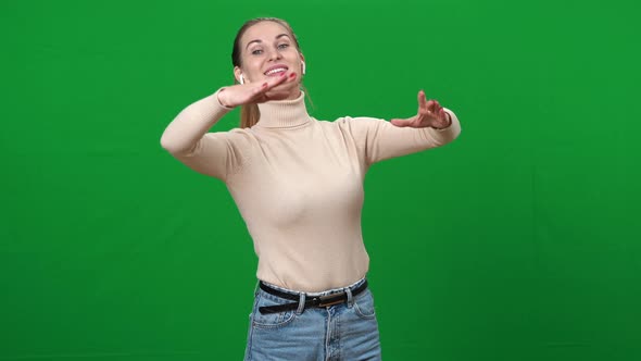 Woman with Toothy Smile in Earphones Imitating Waltzing on Green Screen