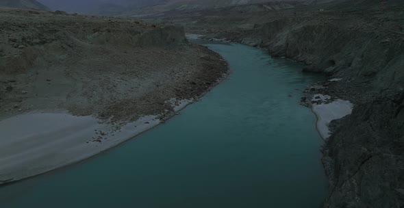 Aerial Over Turquoise Colour River Water In Hunza Valley On Dark Moody Overcast Day