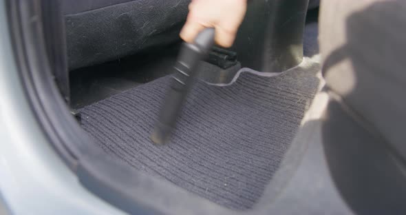Person Carefully Vacuums Fabric Passenger Mat of the Car with Vacuum Cleaner with Special Nozzle