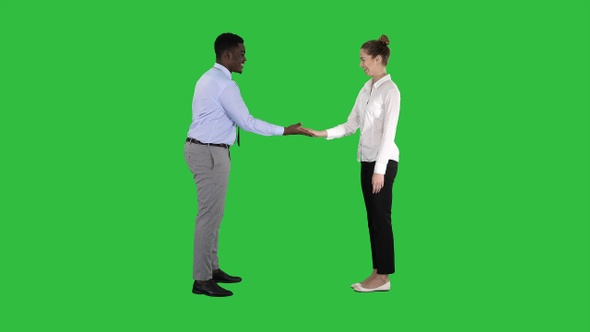 African man and caucasian woman giving low five on a Green