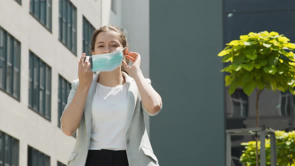 Portrait of a Woman Wearing a Medical Protective Mask and Breathing Air on the Streets 