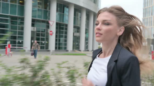 Attractive Businesswoman Running in Street in Slow Motion