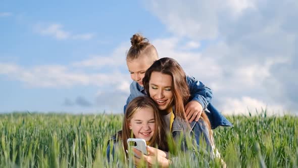 Mom Daughter and Son Taking a Selfie on a Wheat Field on a Background of Sky