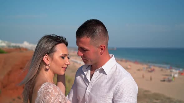 Young Couple on the Beach Embracing and Admiring the View of the Seascape