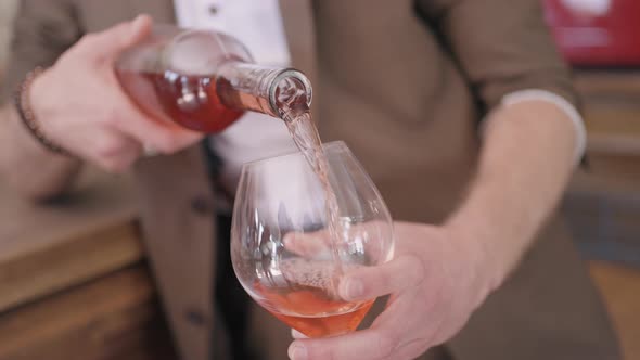 Male sommelier pouring fruit wine at a bar