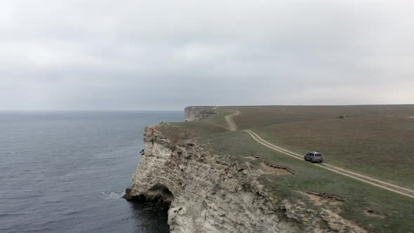 Shooting From Helicopter Suv Automobile Riding on Road Top of High Cliff Near Natural Sea Mountain