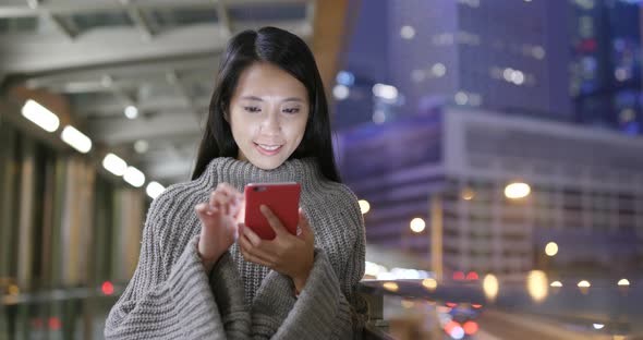 Young woman use of mobile phone in city at night