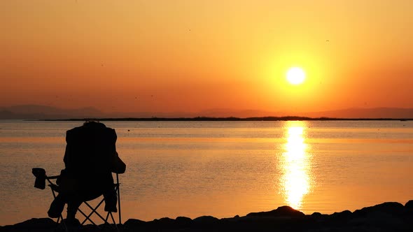 Man In Seat Watching Sunset And Sea