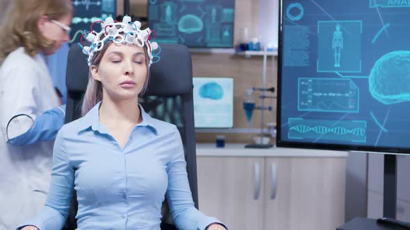 Female Sitting on a Chair with Brainwaves Scaner Headset