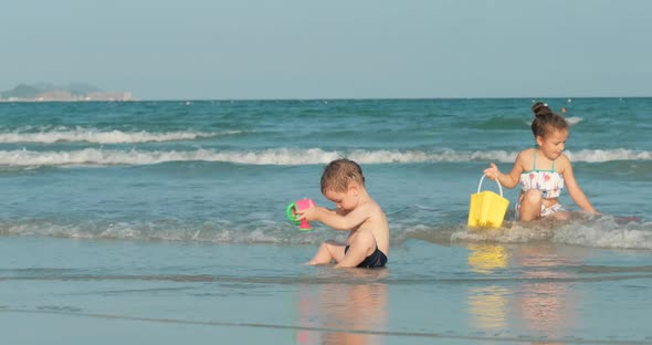 Happy and Carefree Children Playing By the Sea with Sand . Children Playing, Brother and Sister Play