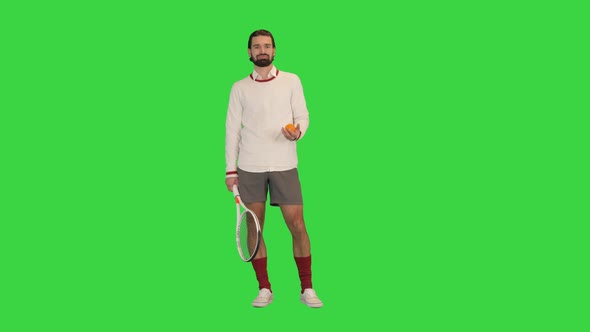 Tennis Player Holding a Racket and Tossing a Ball on a Green Screen Chroma Key