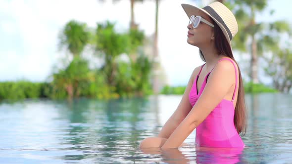 Young asian woman enjoy around outdoor swimming pool for leisure