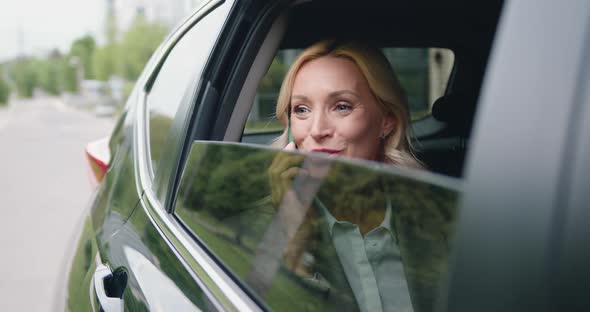 Successful Business Woman Sitting in a Luxury white Car Talking on the Phone