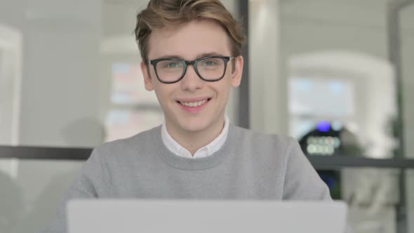 Close Up of Young Man Shaking Head As Yes Sign While Using Laptop