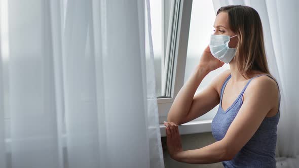 Pensive Female in Protective Respirator Having Loneliness at Home