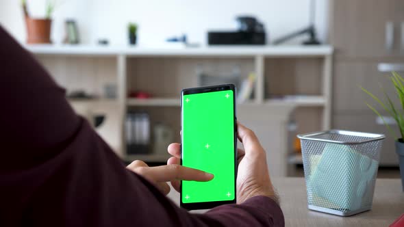 Man Holds a Smarpthone with Green Screen Chroma Mock Up