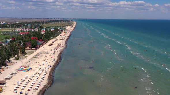 Beautiful flight in summer over the beach. People are resting near the sea.