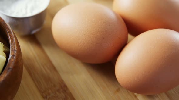 Various ingredients and brown eggs on wooden table 4k