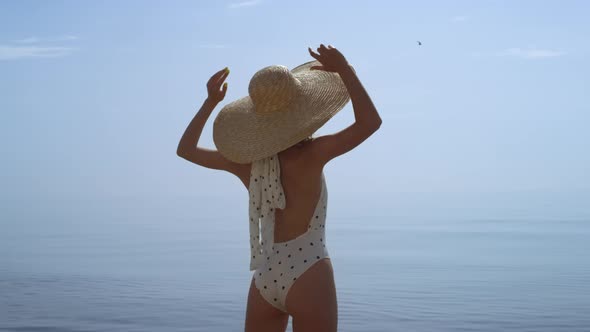 Young Woman Enjoy Seascape with Arms Out to Sides