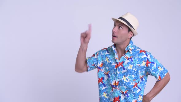 Young Happy Hispanic Tourist Man Thinking While Pointing Up